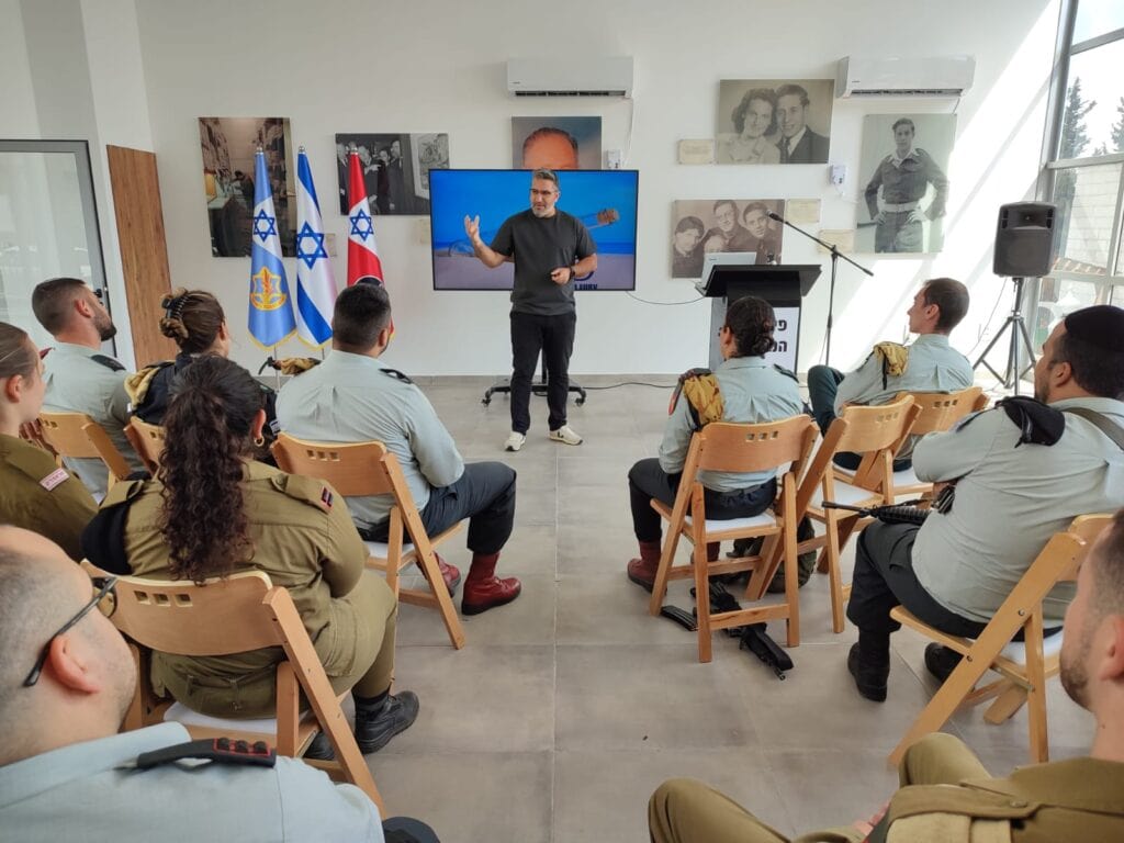 A man in uniform giving a presentation to a group of people.